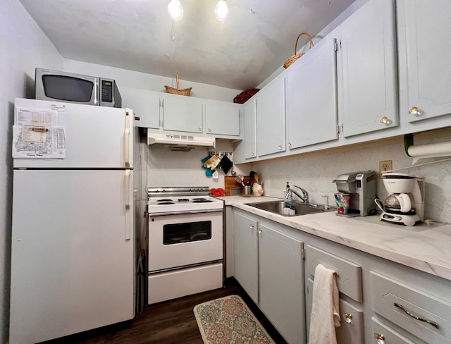 kitchen with white appliances, dark wood-type flooring, white cabinets, sink, and tasteful backsplash