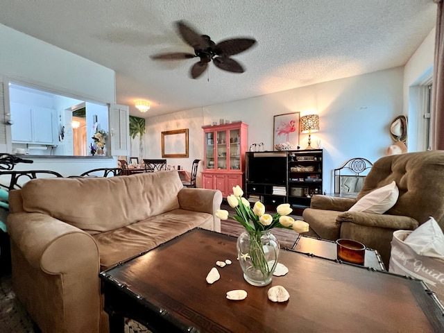 living room featuring a textured ceiling and ceiling fan