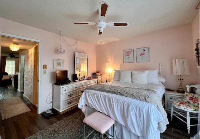 bedroom with a textured ceiling, dark hardwood / wood-style floors, and ceiling fan