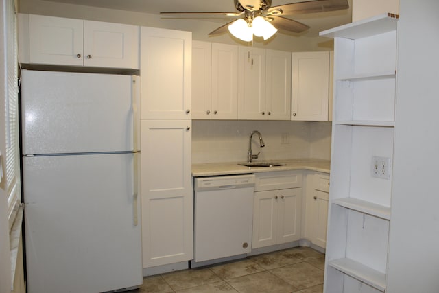 kitchen featuring tasteful backsplash, white appliances, sink, light tile patterned floors, and white cabinetry