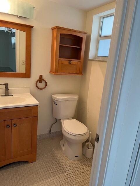 bathroom with toilet, vanity, and tile patterned floors