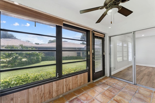 unfurnished sunroom featuring ceiling fan