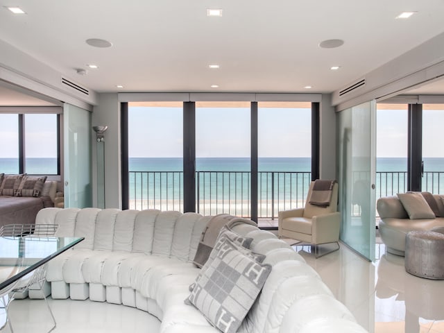 living room featuring a healthy amount of sunlight, a water view, and light tile patterned flooring