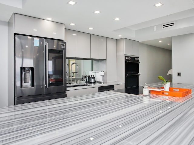 kitchen featuring sink, black double oven, stainless steel fridge, cooktop, and white cabinetry