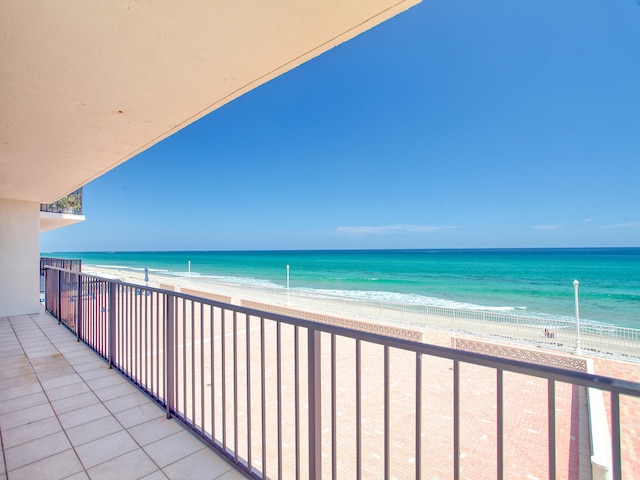 balcony featuring a water view and a view of the beach