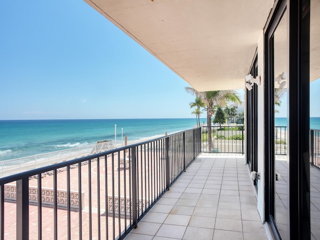 balcony featuring a view of the beach and a water view