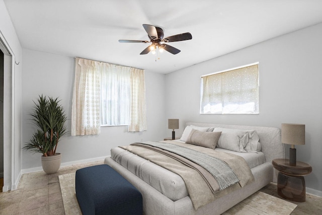 bedroom featuring multiple windows and ceiling fan