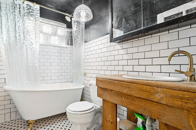 bathroom featuring tile patterned floors, a washtub, sink, tile walls, and toilet