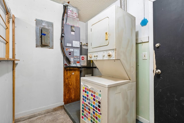 laundry area featuring a textured ceiling, electric panel, and stacked washer and clothes dryer