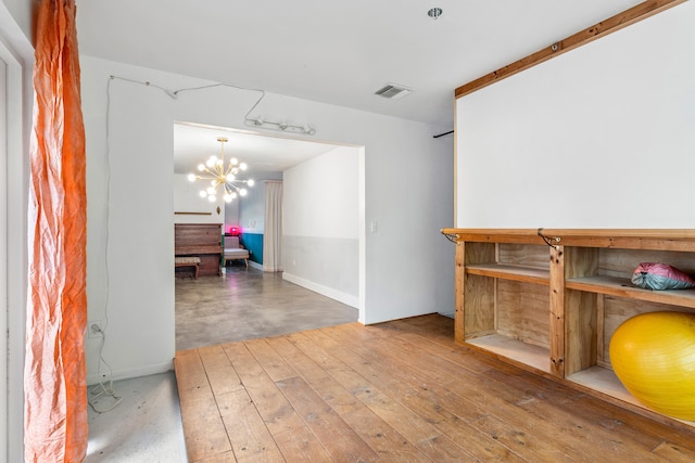 hall with hardwood / wood-style flooring and a notable chandelier