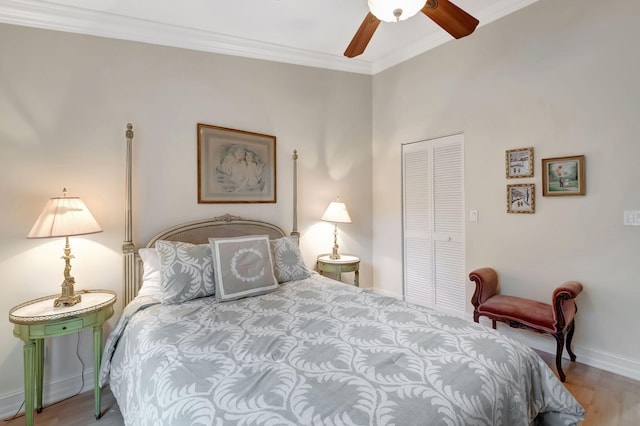 bedroom featuring hardwood / wood-style flooring, ceiling fan, ornamental molding, and a closet