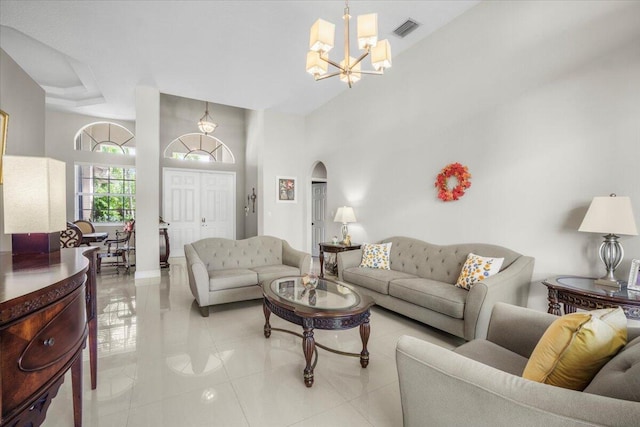 living room featuring a high ceiling, light tile patterned floors, and a notable chandelier