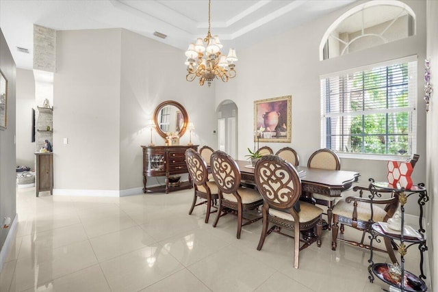 dining space featuring a chandelier, light tile patterned floors, and a towering ceiling