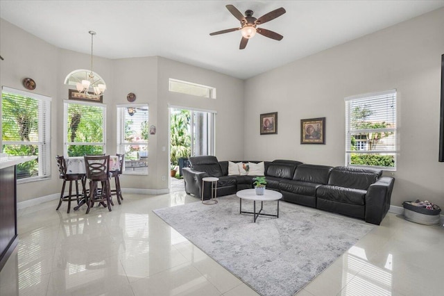 living room with light tile patterned floors, ceiling fan with notable chandelier, and a wealth of natural light