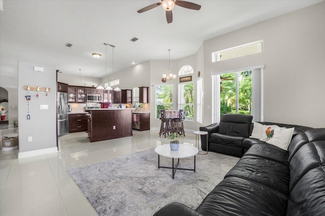 living room with light tile patterned floors and ceiling fan with notable chandelier