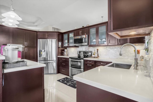 kitchen with sink, pendant lighting, decorative backsplash, light tile patterned floors, and appliances with stainless steel finishes