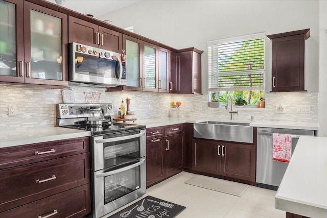 kitchen featuring appliances with stainless steel finishes, backsplash, light tile patterned floors, and sink