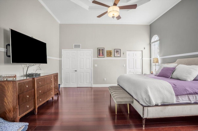 bedroom featuring ceiling fan, crown molding, dark wood-type flooring, and a closet