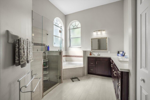 bathroom featuring wood-type flooring, vanity, and separate shower and tub