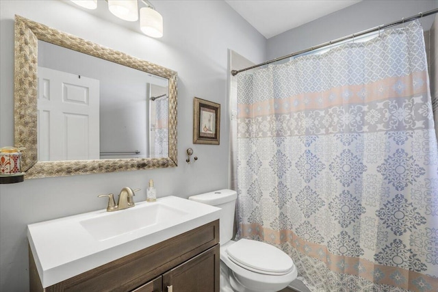 bathroom featuring a shower with shower curtain, vanity, and toilet