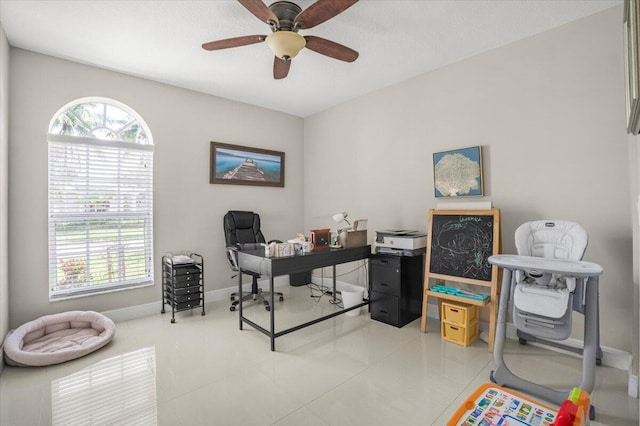 home office with ceiling fan, a healthy amount of sunlight, and light tile patterned flooring