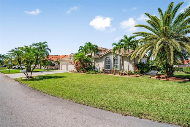 mediterranean / spanish-style home with a front lawn and a garage