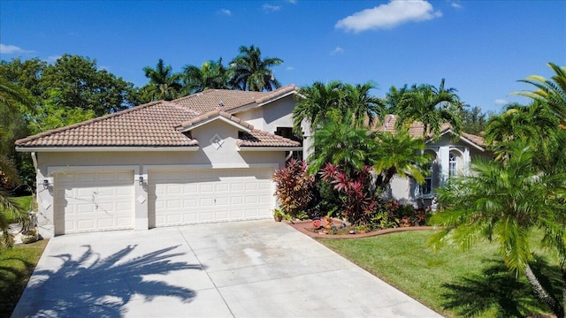 mediterranean / spanish home with a front lawn and a garage