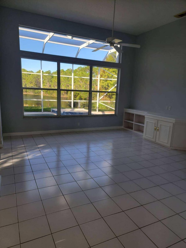 unfurnished dining area with a water view, a healthy amount of sunlight, and light tile patterned flooring