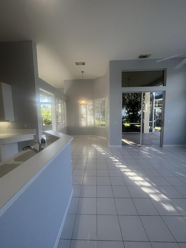 kitchen with sink, light tile patterned floors, and hanging light fixtures