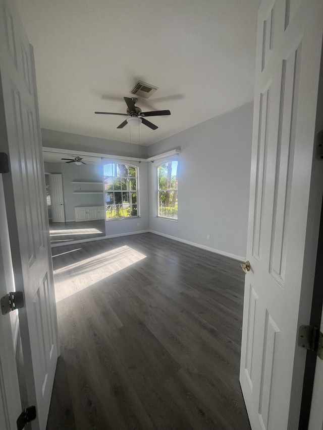 empty room with dark hardwood / wood-style floors and ceiling fan