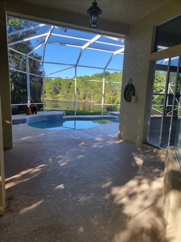 view of pool with a water view, a patio area, and a lanai