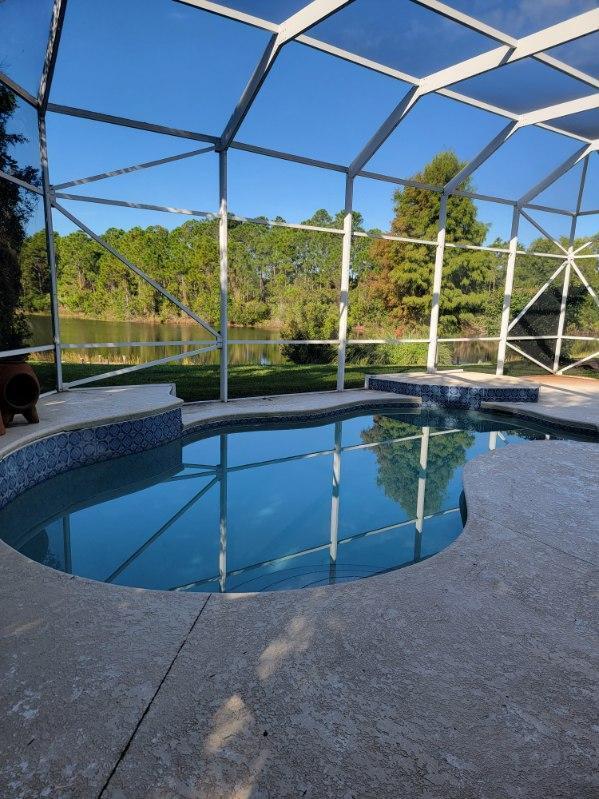 view of swimming pool with a water view and a lanai