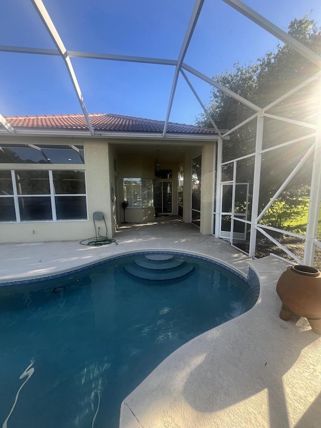 view of swimming pool featuring a patio area and glass enclosure