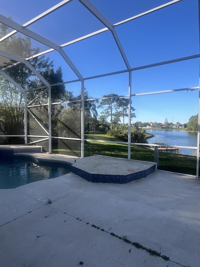 view of pool featuring a patio, a water view, and glass enclosure