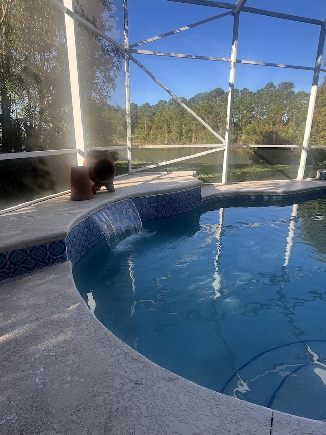 view of swimming pool with pool water feature and glass enclosure