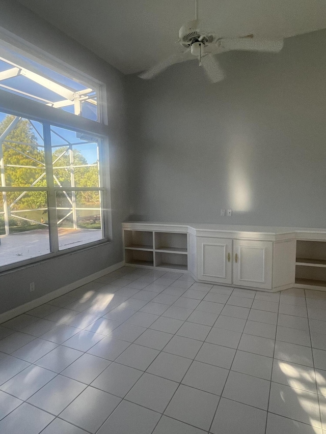 empty room with ceiling fan and light tile patterned flooring