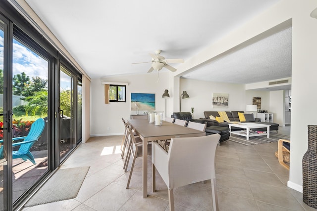 tiled dining room with ceiling fan and vaulted ceiling