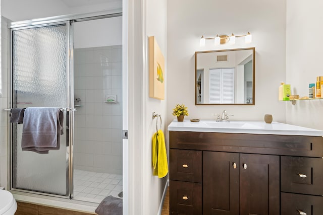 bathroom with vanity, toilet, and a shower with shower door