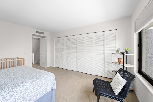 bedroom with light carpet and a closet