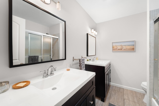 bathroom with hardwood / wood-style floors, vanity, a shower with shower door, and toilet