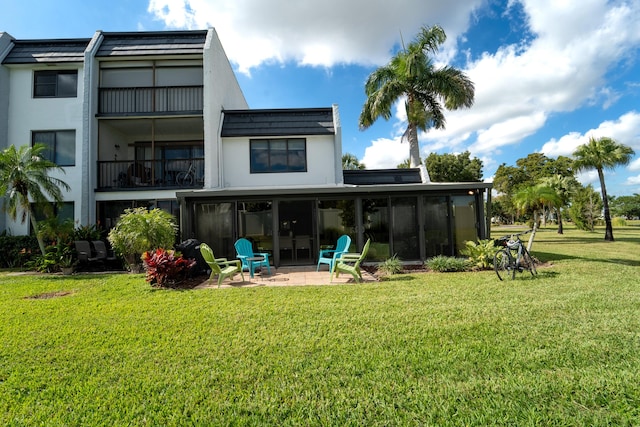 back of house featuring a patio, a sunroom, and a lawn