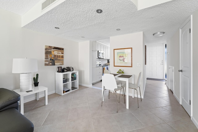 tiled dining room with a textured ceiling