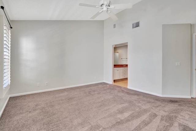 spare room with ceiling fan, light colored carpet, a textured ceiling, and high vaulted ceiling