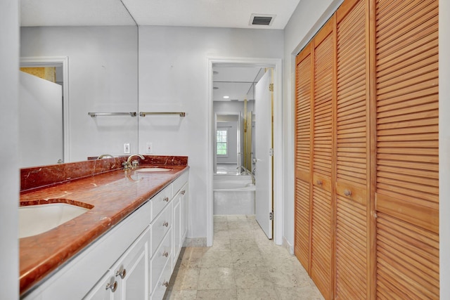 bathroom with vanity and a tub