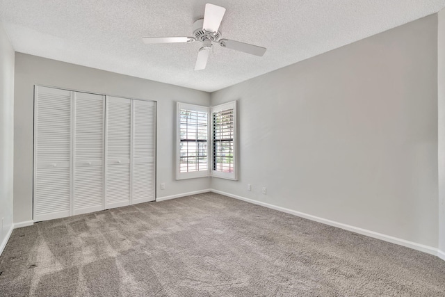 unfurnished bedroom with carpet, ceiling fan, a textured ceiling, and a closet