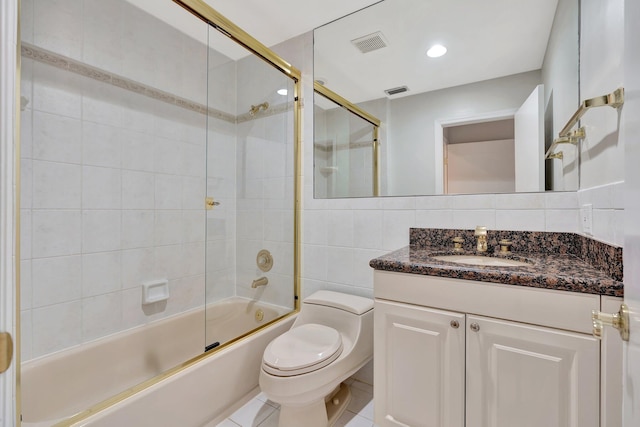 full bathroom featuring vanity, backsplash, combined bath / shower with glass door, tile patterned flooring, and toilet