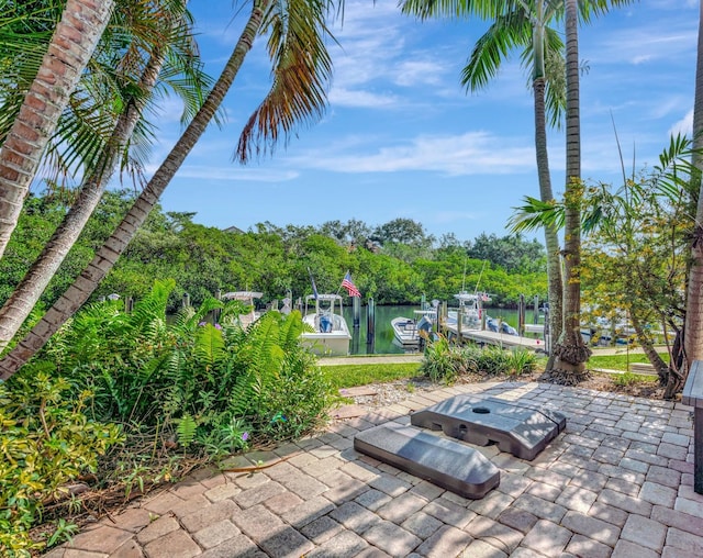 view of patio with a water view and a dock