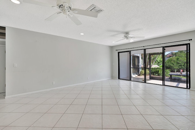 empty room featuring ceiling fan, light tile patterned floors, and a textured ceiling