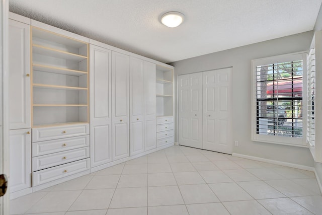 unfurnished bedroom with light tile patterned floors and a textured ceiling