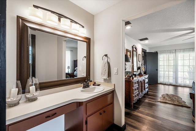 bathroom with vanity, wood-type flooring, and a textured ceiling